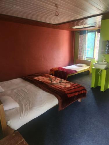 a bedroom with two beds and a sink in it at Shantubaug in Satara