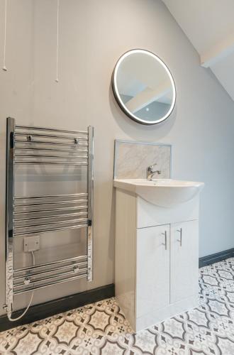 a bathroom with a sink and a mirror on the wall at The Shaftesbury House - 8 Bedroom House in Stockton-on-Tees