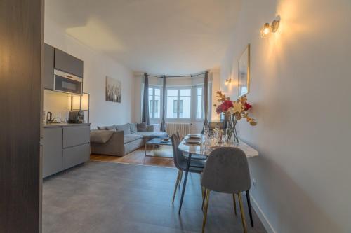 une cuisine et un salon avec une table et des chaises dans l'établissement Saint Georges Suite Triangle d'Or, à Lyon