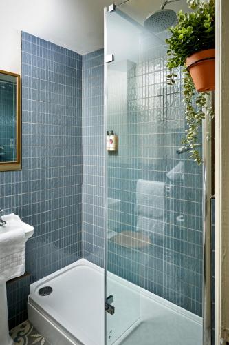 y baño con ducha de azulejos azules. en The Trout at Tadpole Bridge, en Faringdon