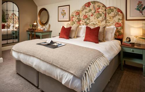 Un dormitorio con una cama grande con un cabecero grande. en The Trout at Tadpole Bridge, en Faringdon