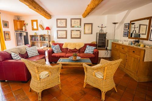 un salon avec un canapé rouge et deux chaises dans l'établissement Mas St. Joseph, à Ille-sur-Têt