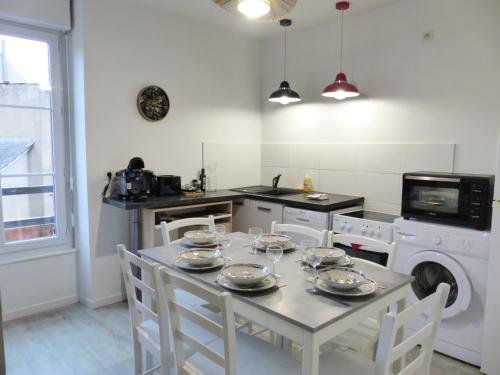 - une cuisine avec une table et de la vaisselle dans l'établissement VIARME - Grand T4, 6 pers au calme en centre ville, à Nantes