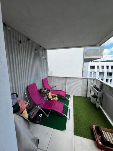 une chambre avec deux chaises et une télévision sur un balcon dans l'établissement Auberge Chambre La Bienveillance, à Lormont