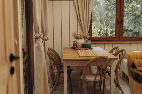 a dining room table with chairs and a window at Jutowa Chata - nocleg bliżej natury in Łask