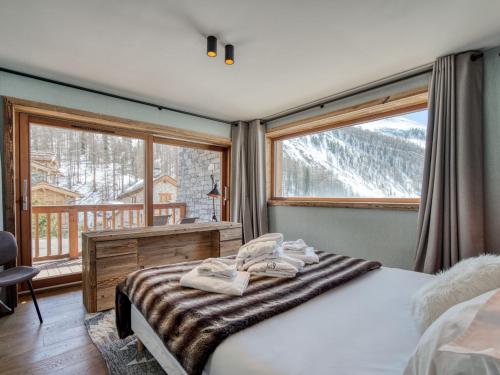 a bedroom with a bed and a large window at Chalet de luxe avec piscine, sauna, hammam, cinéma et salle de jeu - FR-1-694-3 in Val dʼIsère