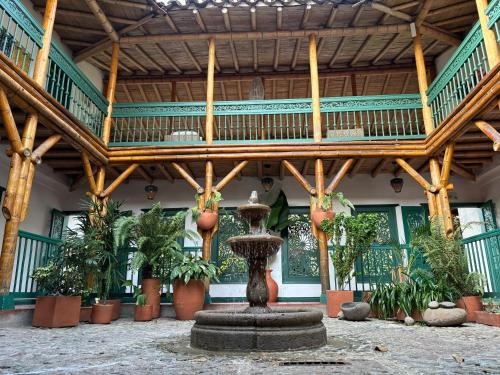 a fountain in the middle of a building with a wooden ceiling at Hacienda Bambusa in El Caimo