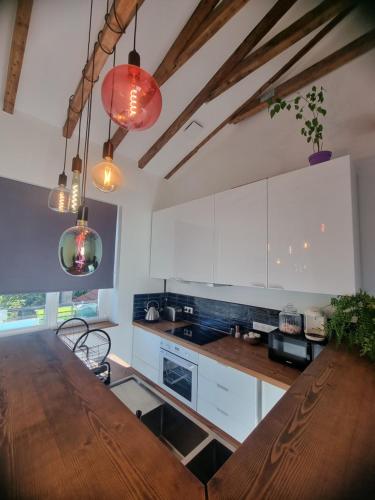 une cuisine avec des armoires blanches et une table en bois dans l'établissement Un appartement charmant à deux pas de Paris !, à Le Pré-Saint-Gervais