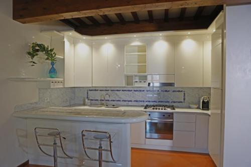 a kitchen with white cabinets and a sink and a stove at Maison B in Prato