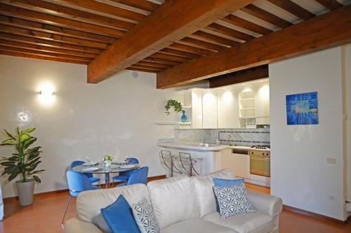 a living room with a couch and a table and a kitchen at Maison B in Prato