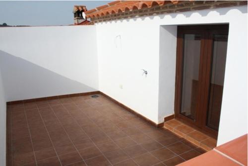 een kamer met een witte muur en een tegelvloer bij Apartamentos Turisticos Rurales El Pua in Cazalla de la Sierra