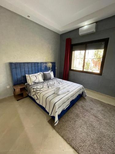 Un dormitorio con una gran cama azul y una ventana en Deluxe Private Villa, en Marrakech