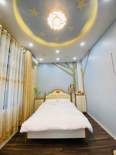 a bedroom with a bed with a tree on the ceiling at Mây Homestay in Cao Bằng in Cao Bằng