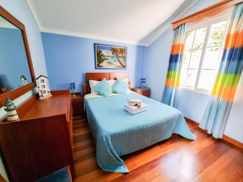 a blue bedroom with a bed with a tray on it at Villa Atlântico, your family&friends retreat in Ponta do Sol