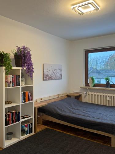 a bedroom with a bed and a book shelf at Gemütliche Ostsee Oase, 3 Zimmer mit Balkon in Bad Schwartau in Bad Schwartau