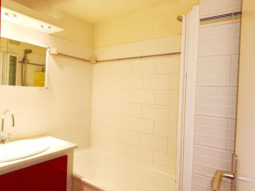 une salle de bain avec une baignoire blanche et un lavabo dans l'établissement Le Tavaillon, à Saint-Gervais-les-Bains