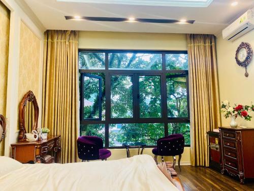 a bedroom with a large window and purple chairs at Mây Homestay in Cao Bằng in Cao Bằng