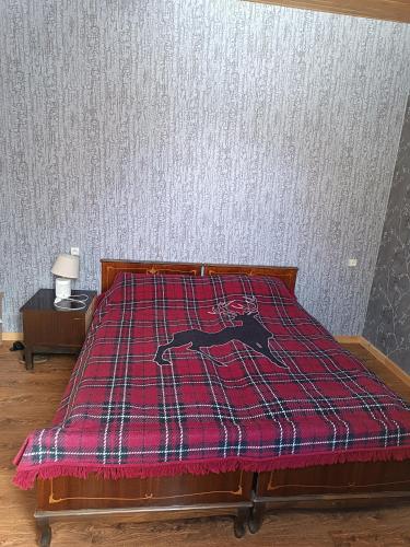 a bed with a red blanket with a horse on it at Ushkhvani in Mestia