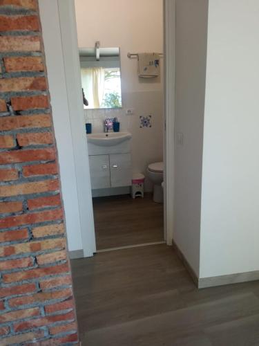 a bathroom with a brick wall and a sink at ToviMar Apartments in Taormina