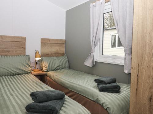 a bedroom with two twin beds and a window at 5 Manor Park in Bideford