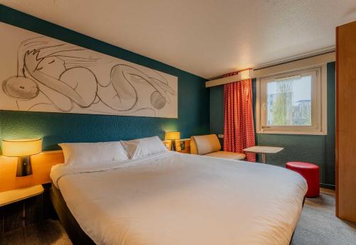 une chambre d'hôtel avec un grand lit et une fenêtre dans l'établissement B&B HOTEL Lille Villeneuve d'Ascq Grand Stade, à Villeneuve d'Ascq