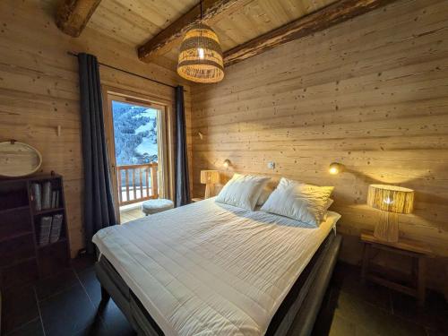 a bedroom with a bed in a log cabin at Lodge alpin chaleureux, 4 chambres, 10 pers, parking, terrasse, Arêches-Beaufort - FR-1-342-330 in Beaufort