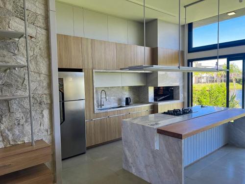 a kitchen with a counter and a refrigerator at Casa Maravilhosa Cond Riviera Xangrila in Xangri-lá