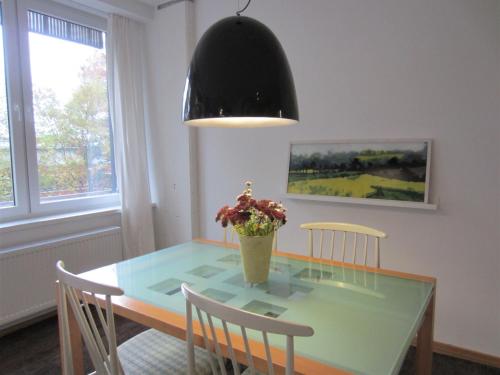 a dining room table with a vase of flowers on it at K9 Wohnungen in Münster