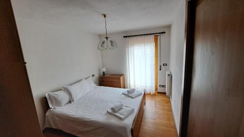 a bedroom with a white bed with two towels on it at Villa Clelia in Auronzo di Cadore