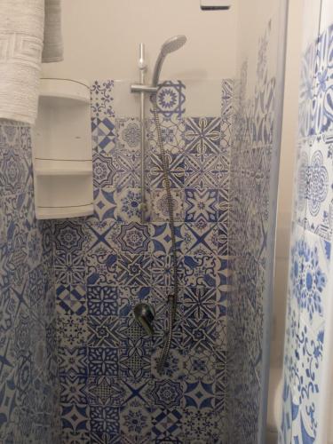 a shower in a bathroom with blue and white tiles at ToviMar Apartments in Taormina