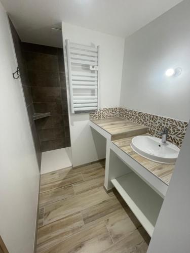 une salle de bain blanche avec un lavabo et une douche dans l'établissement La suite Terrasse du doux refuge, à Esquay-sur-Seulles