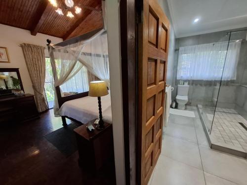 a bedroom with a shower and a bed and a bathroom at St. Lucia Wetlands Guest House in St Lucia