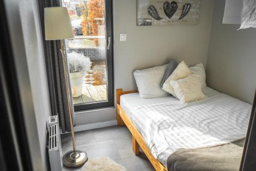 a small bedroom with a bed and a window at The Grey Pearl Houseboat in Zwartsluis