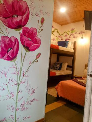 a bedroom with pink flowers painted on the wall at Hotel Boutique Stay La 10 in Medellín
