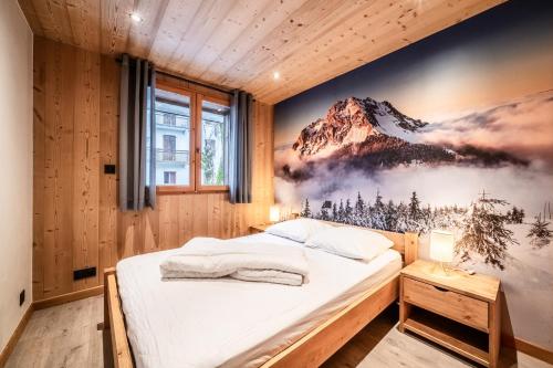 1 dormitorio con un mural de montaña en la pared en LES SERMES M304, en Morzine