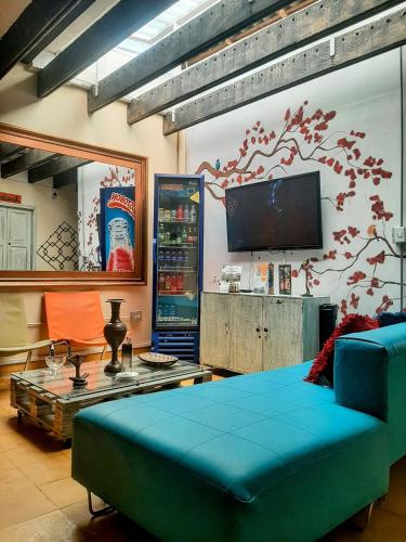 a living room with a blue couch and a tv at Hotel Boutique Stay La 10 in Medellín