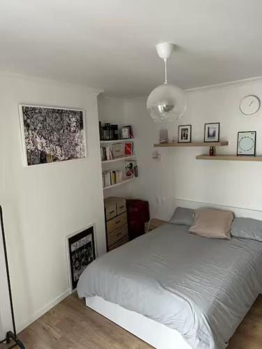 - une chambre blanche avec un lit et une lampe dans l'établissement Cozy Appartment in Voltaire, à Paris