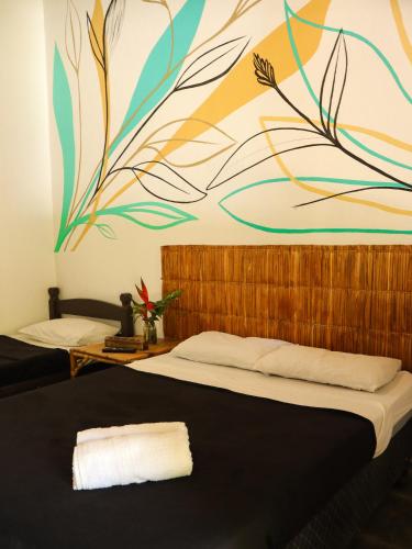 a bedroom with a large mural on the wall at Pousada e Hostel Marthi in Ubatuba