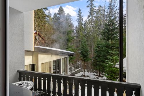 a balcony with a view of a forest at SEVEN Apartments in Predeal