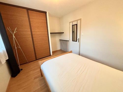 a bedroom with a bed and a sliding glass door at Charmant F2 au cœur de Royat in Royat