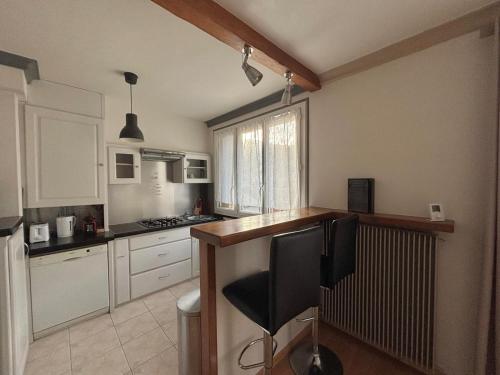 une cuisine avec des armoires blanches et un comptoir en bois dans l'établissement Charmant F2 au cœur de Royat, à Royat