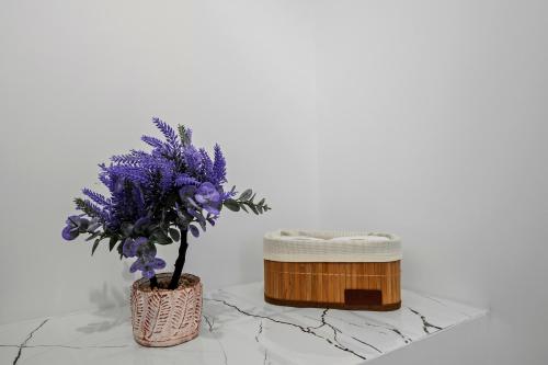 a vase with purple flowers sitting next to a box at SEVEN Apartments in Predeal