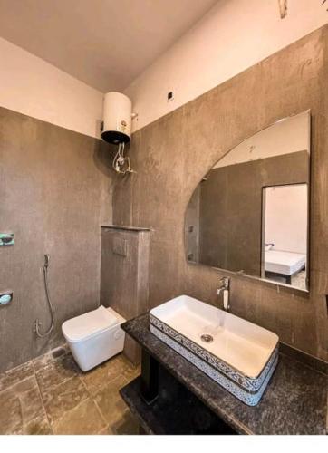 a bathroom with a sink and a toilet and a mirror at Bagol Niwas in Udaipur