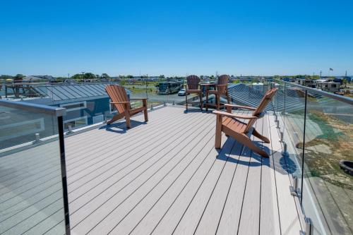 a deck with two chairs and a table on a roof at Chincoteague Bay RV Resort & Cottages in Chincoteague