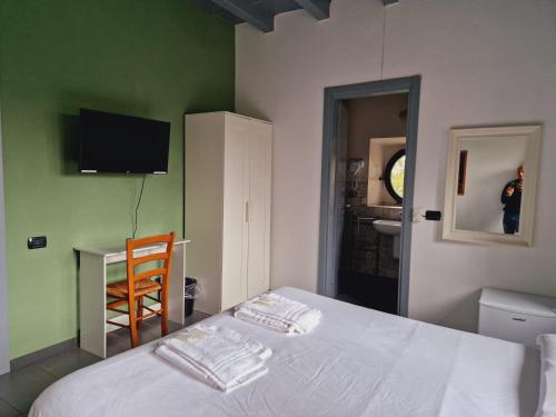 a bedroom with a bed and a tv on the wall at B&B e Ostello, Parco di Monza, CASCINA COSTA ALTA in Monza