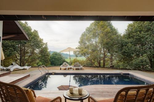 a swimming pool in a house with a view of trees at Pickleball Peak Villa Langkawi by Langit Hill in Ulu Melaka