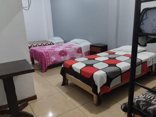 a room with two beds and a chair in it at San José II in Nazca