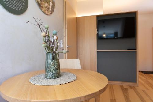 a vase of flowers on a table in a room at Forsthaus Apartments - Die Ruheoase nahe Klaffer in Klaffer am Hochficht