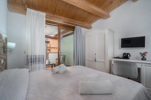 a bedroom with a white bed with towels on it at Bosa Queen House in Bosa