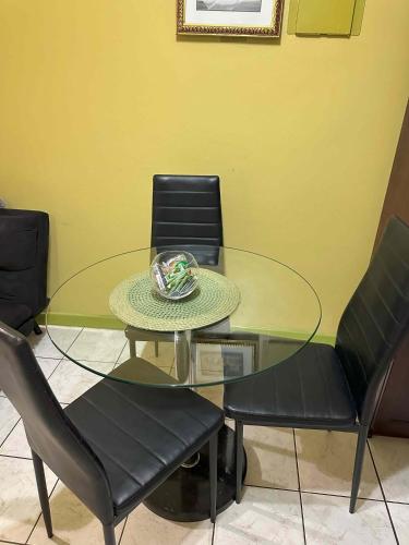 a glass table with two chairs and a plate on it at Hylton New Kingston 21 in New Kingston